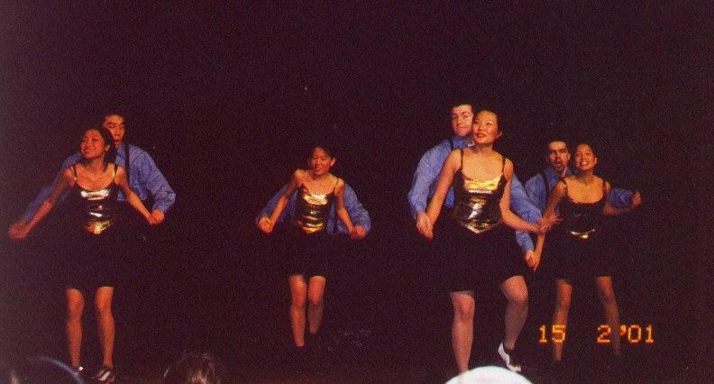 wing dance ensemble performing a choreographed routine onstage in coordinated costumes.